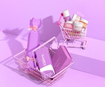 Little baskets with GLAMRDiP manicure products on a lilac background.